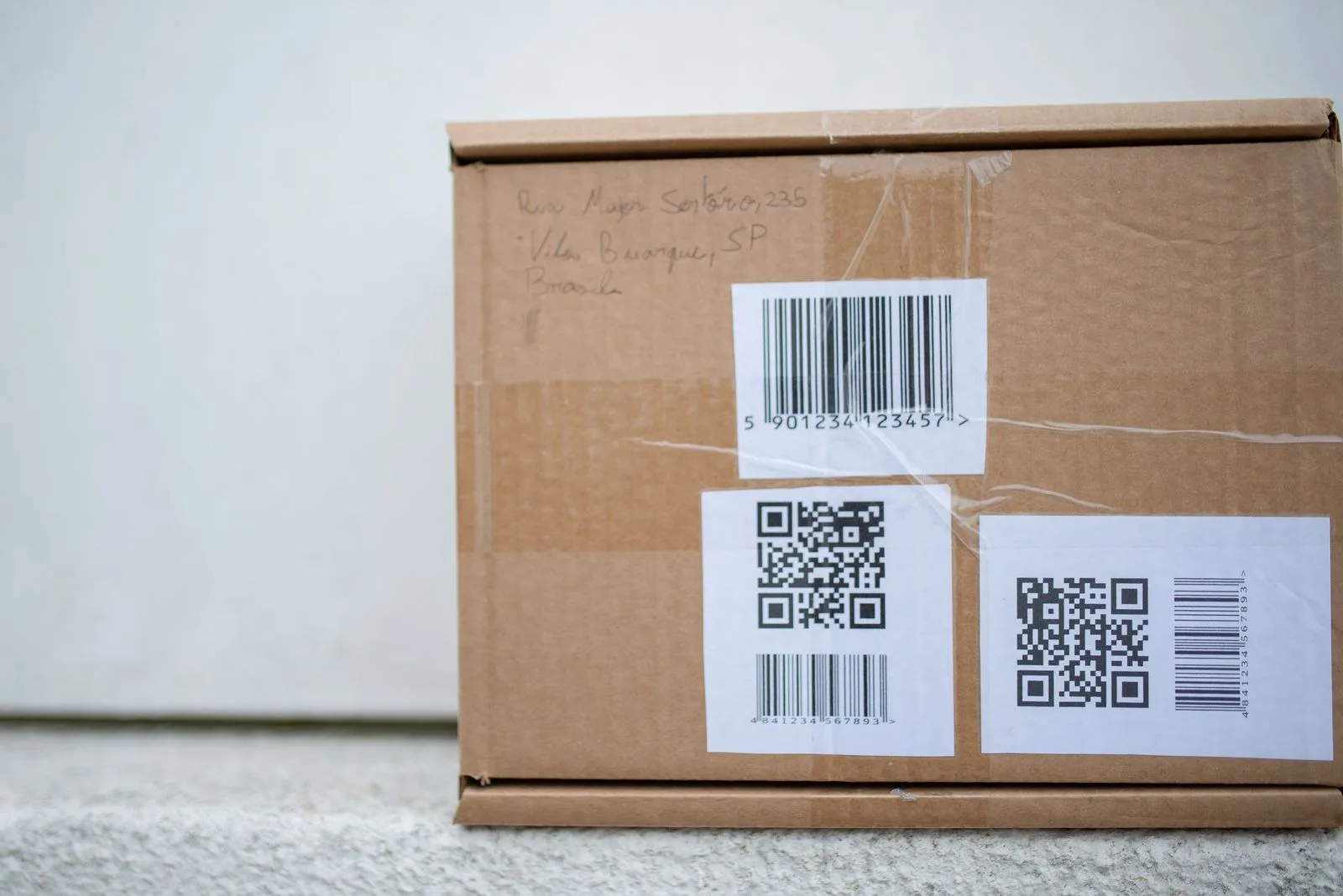 Scatola di cartone con etichette, codice a barre e QR-code